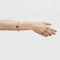 Open bracelet with 18kt gold plating over silver and onyx Cachito Mío
